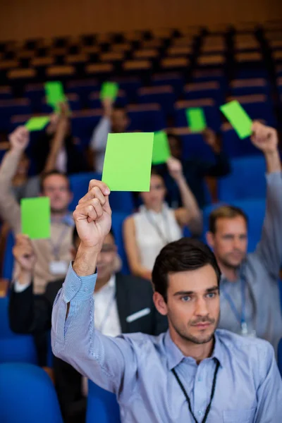 在会议中心举手表示认可的企业高管 — 图库照片