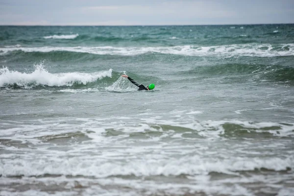 ウェット スーツ スイミング ビーチの海の中の男 — ストック写真