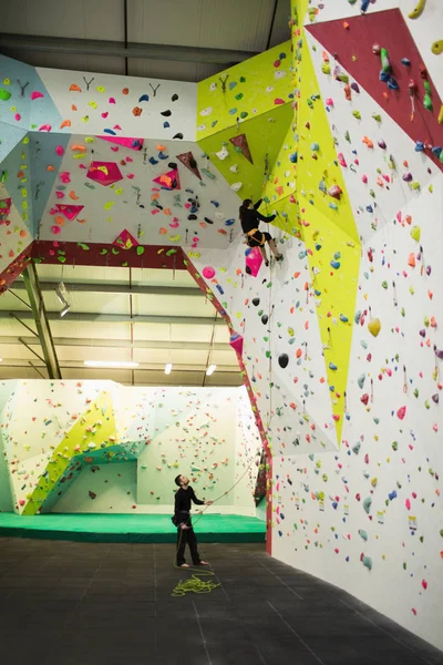 Trainer Assisting Woman While Climbing Artificial Wall Gym — Stock Photo, Image