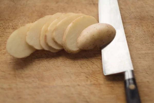 Nahaufnahme Von Geschnittenen Kartoffeln Und Messer Auf Schneidebrett — Stockfoto