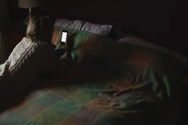 Kobieta Leżąc Przy Użyciu Telefonu Komórkowego Łóżko Sypialni — Zdjęcie stockowe