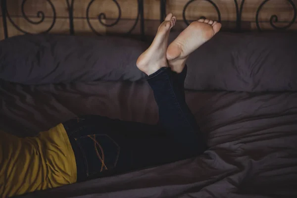 ขาไขว ของผ งนอนบนเต ยงในห องนอนท — ภาพถ่ายสต็อก