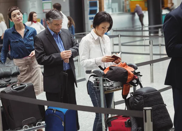 在值机柜台排队等候的乘客 在机场航站楼内携带行李 — 图库照片