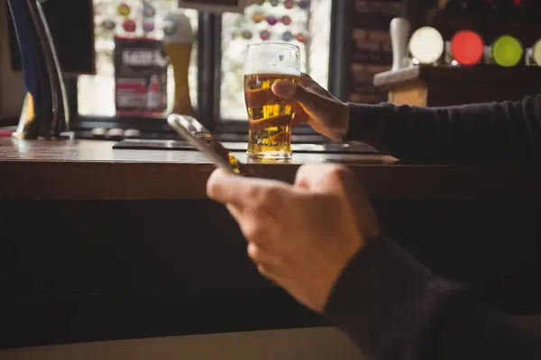 Man Använder Mobiltelefon Med Glas Handen Bar — Stockfoto