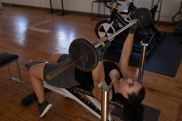 年轻的女拳击手在健身工作室用杠铃锻炼 — 图库照片