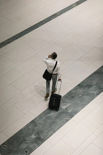 Vista Elevada Empresário Com Mala Viagem Falando Celular Enquanto Caminha — Fotografia de Stock