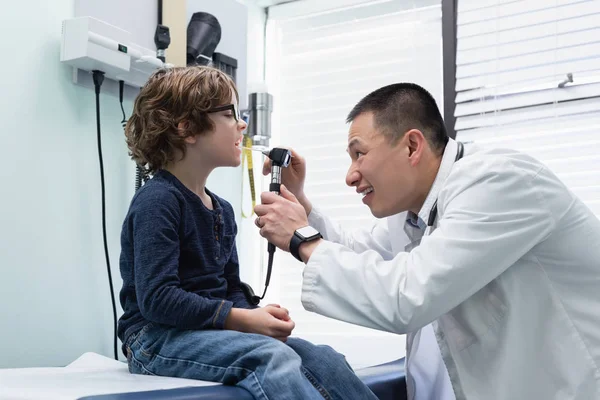 Visão Lateral Jovem Asiático Médico Masculino Examinando Caucasiano Menino Paciente — Fotografia de Stock