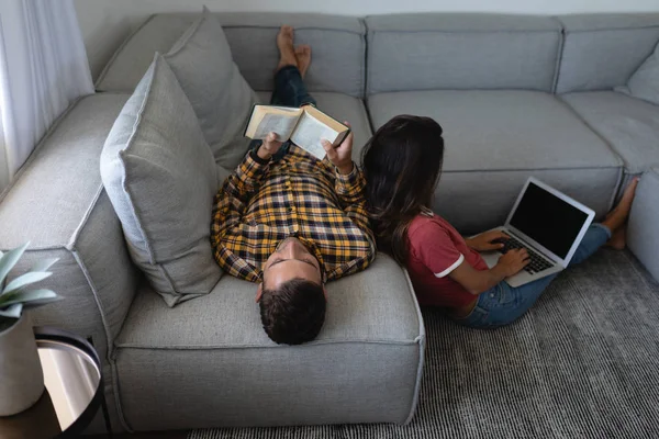 Visão Traseira Mulher Mestiça Usando Laptop Enquanto Homem Caucasiano Livro — Fotografia de Stock