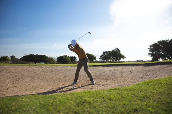 在阳光明媚的日子 一个白人男子在高尔夫球场迎面而来 准备击球 — 图库照片
