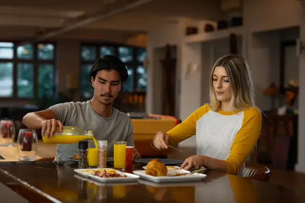 若い混合人種の男とテーブルに座って一緒に朝食を楽しむ若い白人女性のフロントビュー — ストック写真