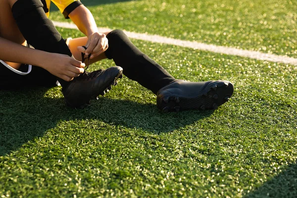 Bir Futbol Sahasında Oturmuş Futbol Ayakkabılarını Giyiyor Antrenman Sırasında Bağcıklarını — Stok fotoğraf