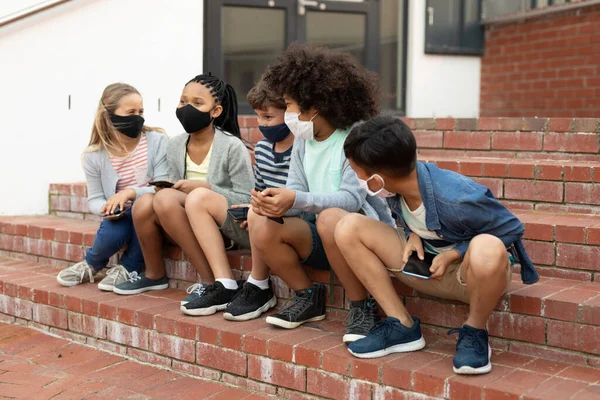Groep Multi Etnische Kinderen Dragen Gezichtsmaskers Met Behulp Van Smartphones — Stockfoto