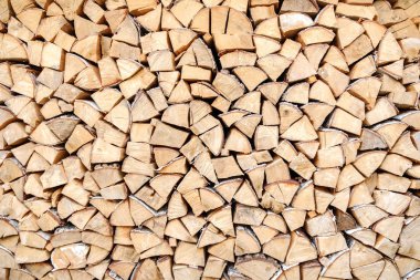 Doğranmış, biçilmiş ve bıçaklanmış yığılmış ahşap kütüklerin arka planı.
