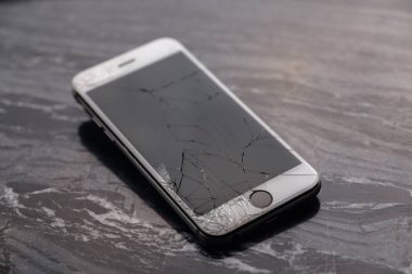 Kırık ve kırık akıllı telefon ekranı. Kırık bir akıllı telefon, monitörü onarmadan ve değiştirmeden önce masanın üzerinde yer alır. Kırık matris.