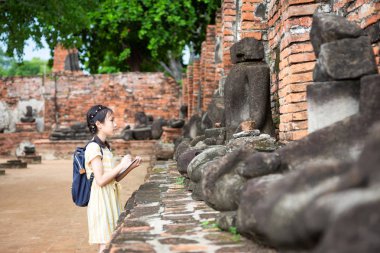 Asyalı Genç kız çalışma ve öğrenme eski eserler, gezi, gezi (Wat Mahathat, Ayutthaya, Tayland okul dışında olduğunu)