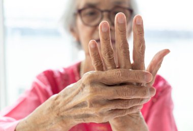 Elderly woman suffering from pain in hand,arthritis,beriberi clipart