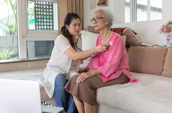 Asiatin Untersucht Körper Mit Stethoskop Seniorin Sitzt Hause Auf Sofa — Stockfoto