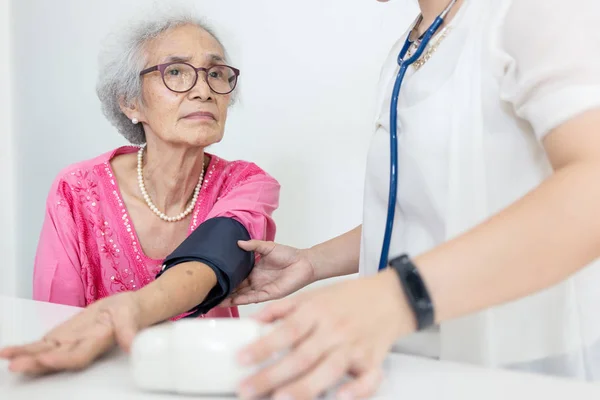 Perawat Perempuan Memeriksa Tekanan Darah Seorang Wanita Tua Rumah Pengurus — Stok Foto