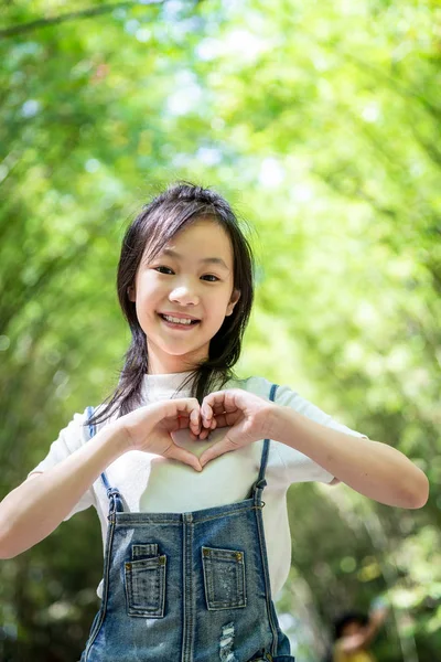 Usmívám Malé Asijské Dívka Směřují Tvar Srdce Rukama Bambusové Lesy — Stock fotografie