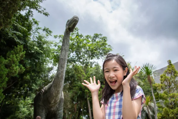 Asijská dívka je šokována, když narazila na dinosaura, Dinosauří park v národním muzeu — Stock fotografie