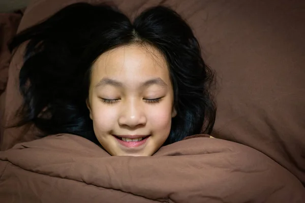 亚洲女孩睡了一个好梦, 微笑在床上在家里 — 图库照片