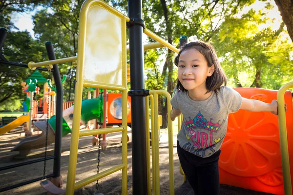 Asiatische kleine Mädchen ist spielen auf einem Spielplatz im Freien und suchen — Stockfoto