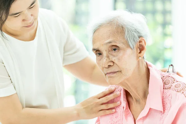 Äldre kvinna med depressiva symtom behöver nära vård, asiatisk kvinna vårdare stödjande, Alzheimerpatient, — Stockfoto