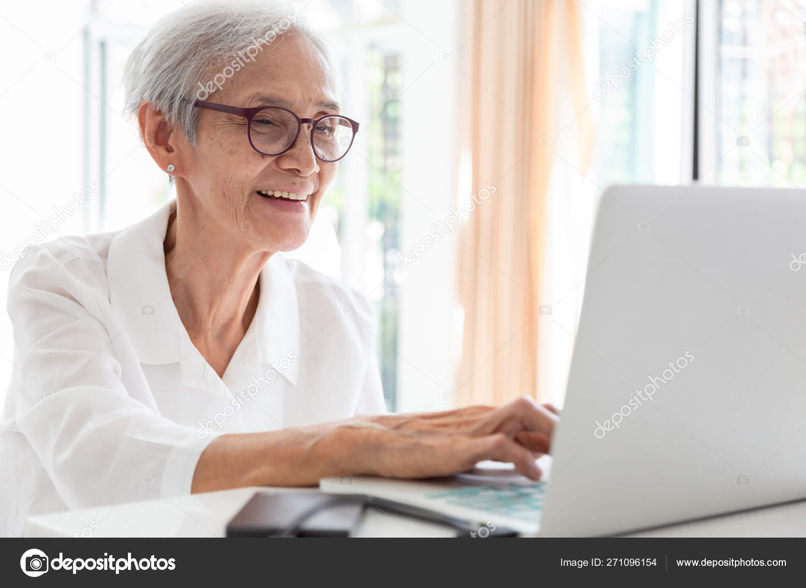 femme senior joyeuse regardant un ordinateur portable et faisant