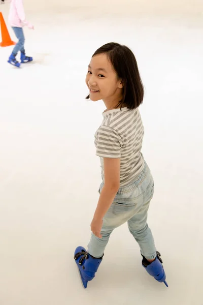Asian little girl on the skating rink in blue ice skates,smile  happily cute child play ice skating in shopping mall outlets,holiday activities,vacation concept — Stock Photo, Image