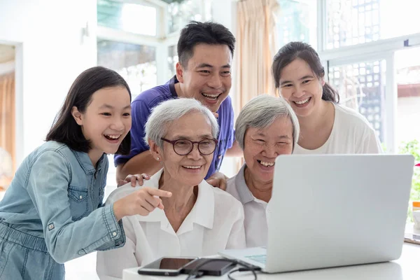 Familia asiática y personas mayores, hombre navegando por Internet, viendo algo interesante con la abuela, feliz sonriente mujer mayor y la familia utilizando ordenador portátil en la mesa en el hogar, la tecnología, la familia, la generación y la gente cóncep —  Fotos de Stock