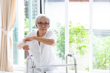 Asya yaşlı insanlar rehabilitasyon sırasında walker ile dinlenmek oturan, yaşlı kadın gözlük giymek, egzersiz ve evde kamera bakarak, konsept sağlık