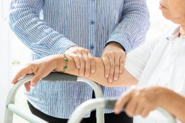 Kolunda ve elinin kadın fizyoterapist tarafından masaj alan Asyalı yaşlı kadın yaralanma nedeniyle,Yaşlı insanlar ağrı muzdarip, osteopati, kadın fizyoterapist yaşlı kadın muayene