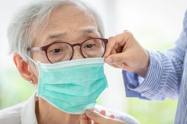 Asiatiska Senior Kvinna lider av hosta med ansiktsmask skydd, äldre kvinna bär ansiktsmask på grund av luftföroreningar, sjuka gamla människor med medicinsk mask; begreppet förorening, damm allergier och hälsa — Stockfoto