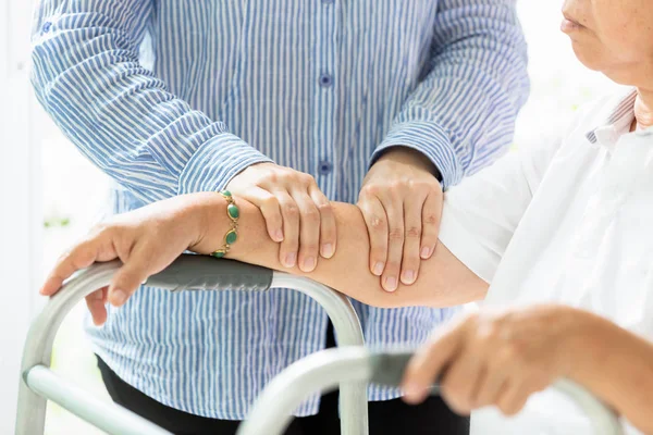 Mujer mayor asiática que recibe masaje por fisioterapeuta femenina de su brazo y mano debido a una lesión, personas mayores que sufren de dolor, osteopatía, fisioterapeuta femenina que examina a la anciana — Foto de Stock