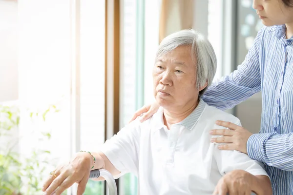 간병인 아시아 딸 또는 젊은 간호사 노인 여자 어깨에 손으로 창을 보고 뒤에 서, 도움, 지원, 정신과 의사와 우울증 환자의 클로즈업, 노인에 대 한 배려, 가족 개념 — 스톡 사진