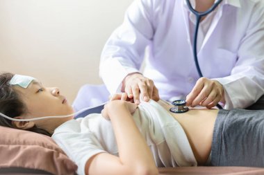 Doktor veya hemşire karın kontrolü, stetoskop ile asyalı çocuk hasta göbek dinleme, genç kadın hekim dispepsi ile küçük kız muayene, gaz, mide ekşimesi, sağlık, tıbbi checkup kavramı