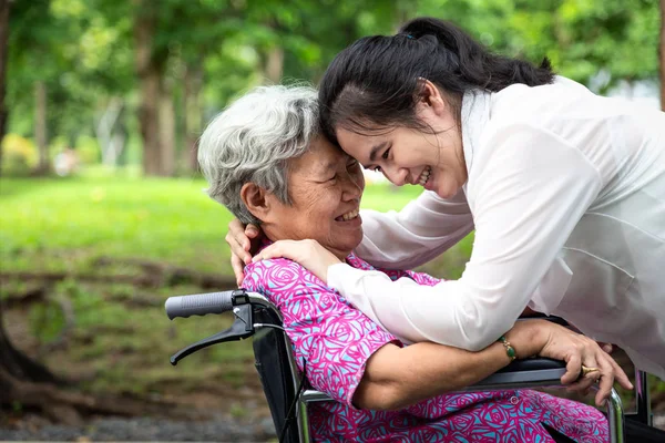 Nahaufnahme, glücklich schöne asiatische Senioren mit erwachsener Frau, die sich umarmt, im Sommer lächelnd, Liebe der Mutter mit ihrer Tochter im Rollstuhl im Outdoor-Park in der Natur, Muttertag, Familie, Liebe, Altenpflegekonzept — Stockfoto