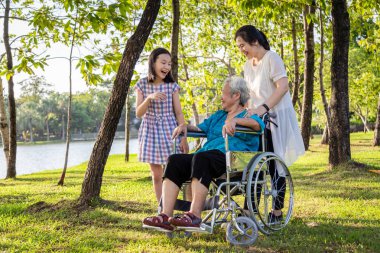 Kızı ve gülümseyen Asya yaşlı anne, çocuk kız veya torunu dinlenmek gülüyor, yürüyüş ve yaz açık parkta birlikte eğlenceli konuşmak, ailesi ile tekerlekli sandalyeyaşlı kadın, mutlu aile, tatil konsepti