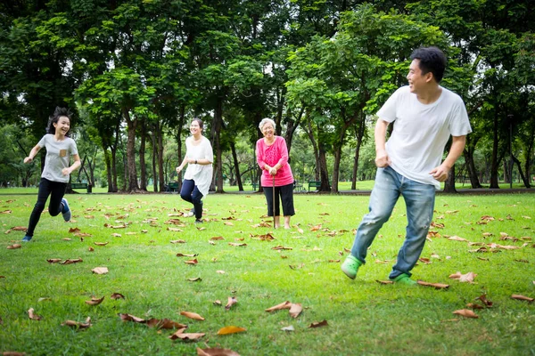 Boldog család, ázsiai kisgyerek lány vagy lánya játszani tag játék, futás apjával, anya, Senior nagymama nyáron zöld természetű, apa, anyu szórakozik, játszani érintés és nevetve a szabadtéri parkban, a szülők élvezik játék — Stock Fotó