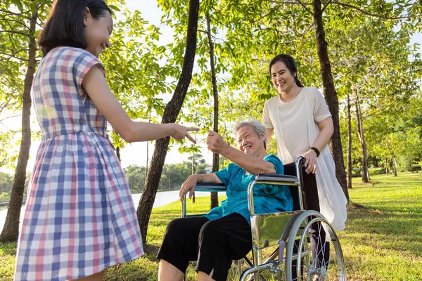 Asiatiska Senior Kvinna spelar Rock Paper sax spel, med lycka, leende med sin dotter och barnbarn på rullstol på Outdoor Park, äldre människor är nöjda med sin familj, barnflicka ha roligt, skrattar tillsammans, lycklig familj Concept — Stockfoto