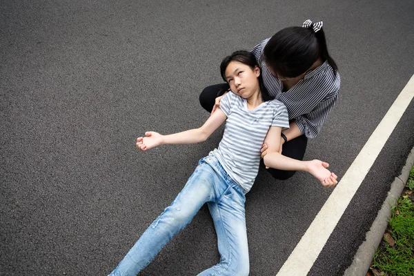 Sick little child girl with epileptic seizures on the street,daughter suffering from seizures,illness with epilepsy during seizure attack,asian young woman or mother care of girl patient,brain,nervous system concept — Stock Photo, Image