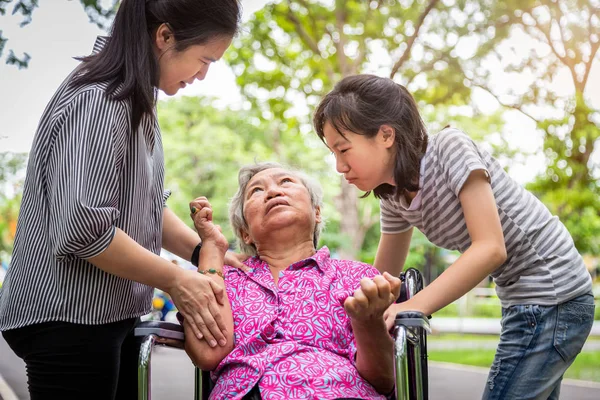 Enferma abuela mayor en silla de ruedas con convulsiones epilépticas en al aire libre, paciente de edad avanzada convulsiones que sufren de enfermedad con epilepsia durante el ataque de convulsiones, hija asiática, nieta llorando, cerebro, concepto del sistema nervioso — Foto de Stock