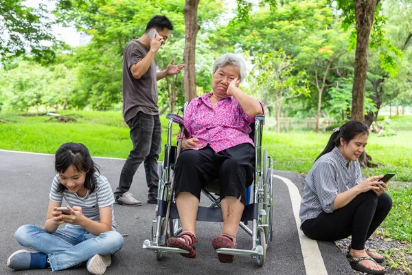 Asiatiska Senior mormor är att ignorera från familj, äldre uttråkad, ledsen, frustrerad, förakt, föräldrar, barnflicka med Internet, mobiltelefon missbrukare, dotter spela spel, sociala problem, familjerelation — Stockfoto