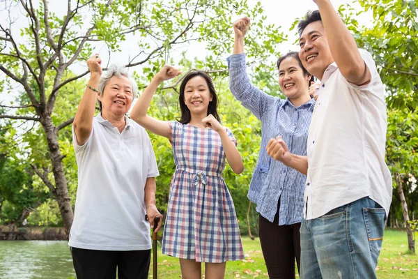 Hurra, Yippee, Sí!, feliz familia asiática levantó los puños con triunfo, gritando emocionado, logro, acuerdo exitoso, alegre, encantado impresionado por su suerte en la lotería, padre, madre, hija, abuela en el parque al aire libre — Foto de Stock