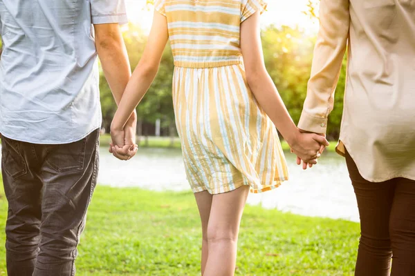 Vista posteriore della famiglia asiatica, mani da primo piano di padre, madre, figlia che si tiene per mano e cammina nella natura, papà, mamma, bambina che si diverte al parco all'aperto in estate, genitori amorevoli, ragazza che passa del tempo insieme, rapporto familiare, felicità — Foto Stock