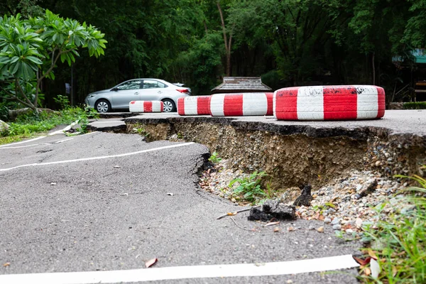 Az út a szabadtéri nyilvános parkolóban összeomlott, az utak összeomlottak, az aszfaltozott út megrepedt és lezuhant, a víz eróziója, a rossz építés vagy földrengés — Stock Fotó