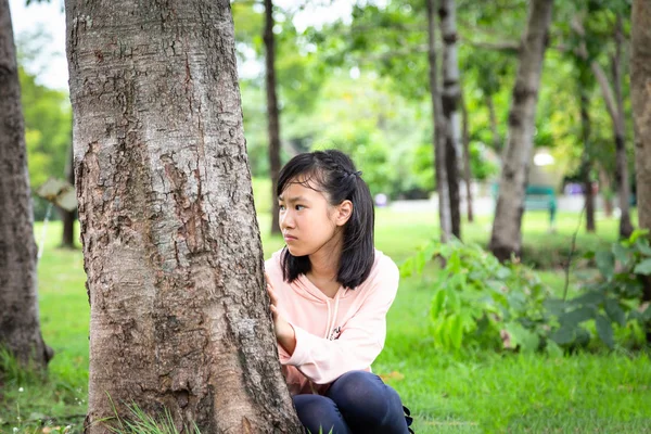 Asian little child girl suffering paranoid,scared,stressed,nervous insecure and hallucinations sitting in outdoor park,feeling afraid increasing fear anxiety,person worried confused face expression,depression,schizophrenia disease concept — Stock Photo, Image