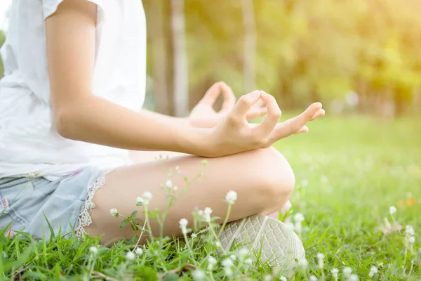 Vértes nő kezek meditál a jóga pózol vagy lótusz helyzetben a zöld fű, ázsiai gyermek lány gyakorló jóga meditáció a szabadtéri parkban, Relax idő, nyugalom, meditáció a természetben, az egészségügyi koncepció — Stock Fotó