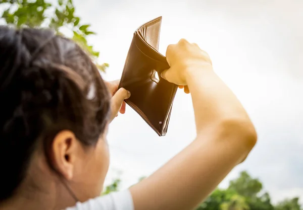 Closeup hand of asian child girl shows her wallet,hand open an empty wallet,no pocket money,spend money extravagantly,extravagant people never save money,bad economics situation,poverty is a necessary consequence of extravagance