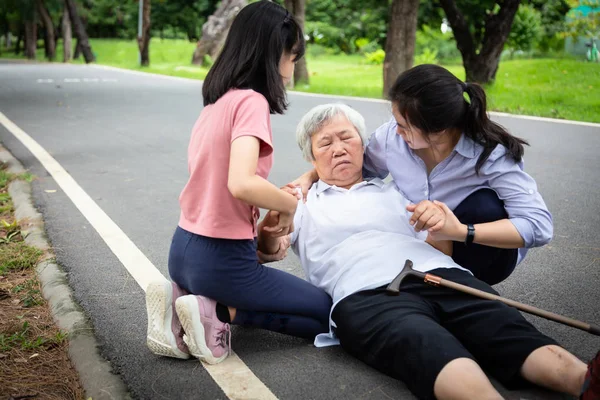 Sjuk asiatisk senior mor med värmeslag, hög temperatur, svindel på golvet efter att ha fallit ner, dotter, barnbarn att hjälpa, ta hand om äldre föll svag, utmattad, lider av sjukdom, solbränna — Stockfoto